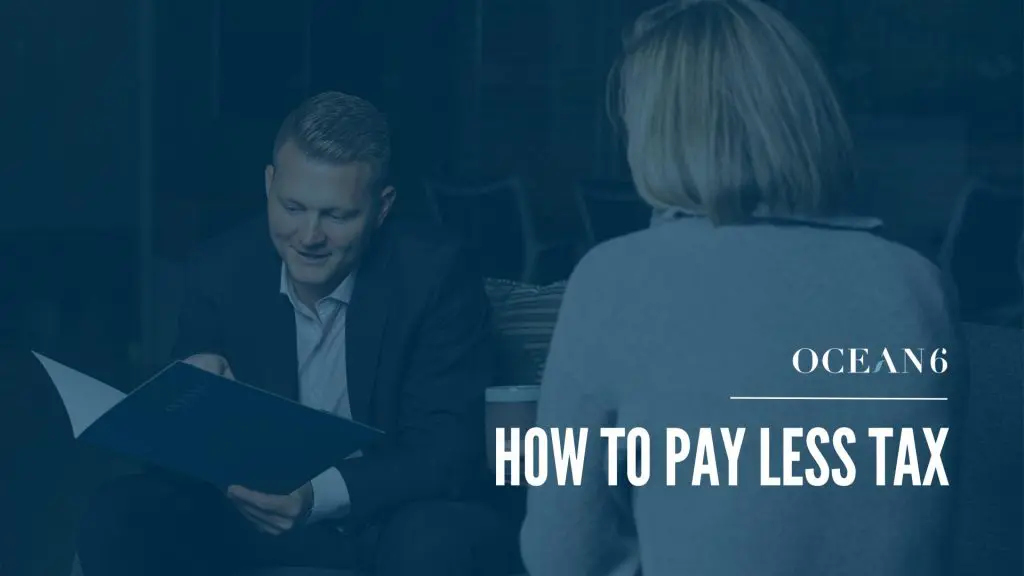 Blog thumbnail with financial advisor holding a folder and sharing information with a woman sitting across from him. How business owners can pay less tax in Canada