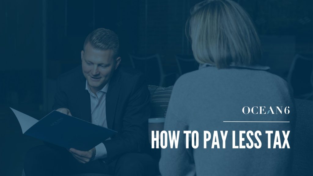 Blog thumbnail with financial advisor holding a folder and sharing information with a woman sitting across from him. How business owners can pay less tax in Canada