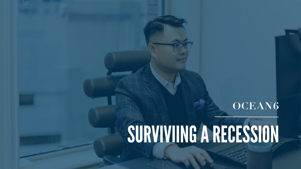 Blog thumbnail on how to survive a recession in 2023. financial advisor sitting at chair on the computer while smiling.