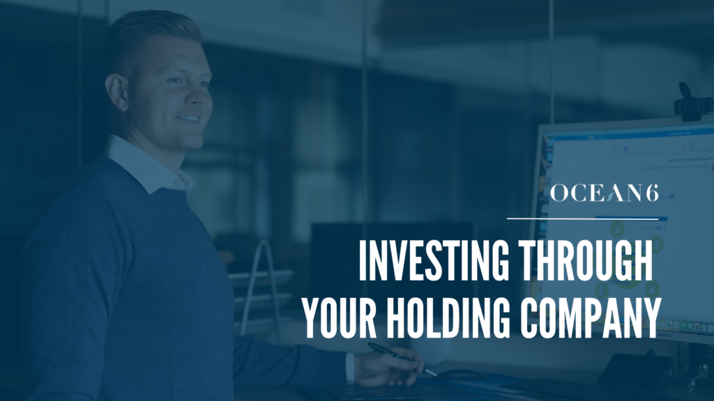 Finanical advisor standing in front of a computer with a chart displayed on the screen. Blog thumbnail - how to invest inside your holding company