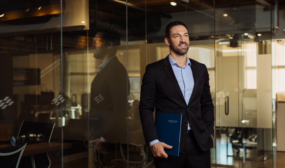 Financial advisor standing and smiling with a folder in his hands