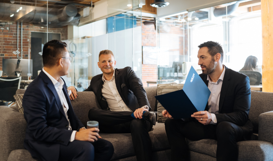 Three financial advisors sitting on a couch, chatting and brainstorming