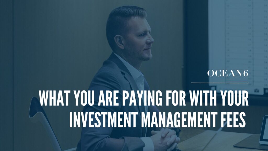 financial advisor sitting in a boardroom as a desk smiling - blog thumbnail what you're paying for with investment fees